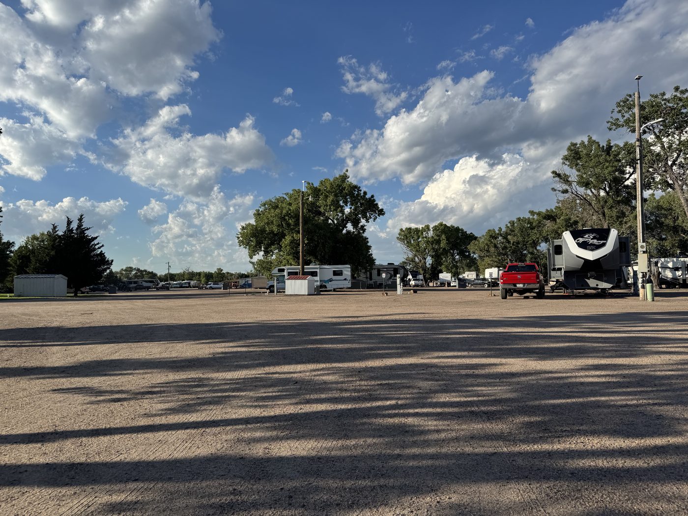 Level pull-through sites at Lincoln Highway RV Park with rigs parked under the trees